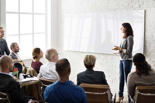 Trainerin spricht im Seminar vor einer Gruppe