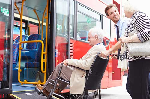 Busfahrer hilft Rollstuhlfahrerin in den Bus