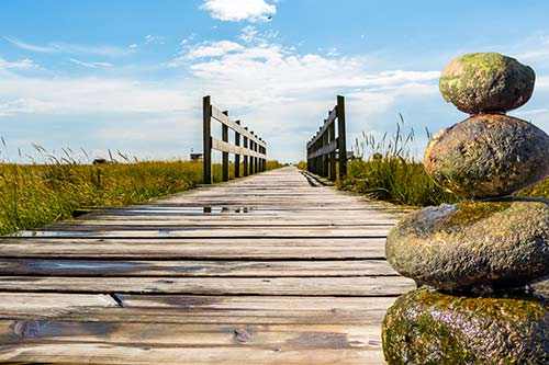 Steg zum Strand und Steine in Balance